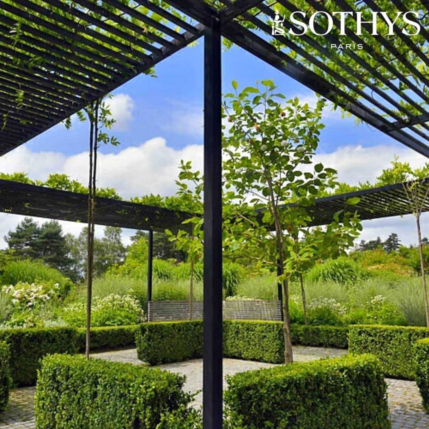 Garden with pergolas and greenery at Sothys Paris, featuring lush plants and hedges.